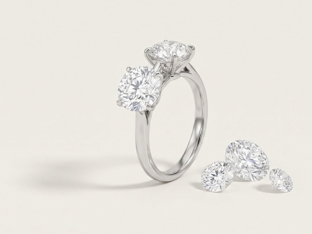 Solitaire diamond ring beside loose brilliant-cut diamonds