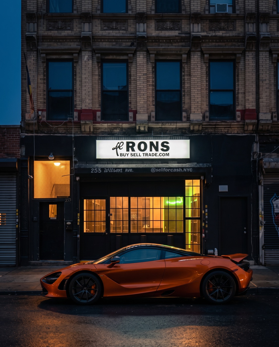 Lil Ron's at 253 Wilson Ave in Bushwick, Brooklyn, lit up at night with a McLaren parked at the curb